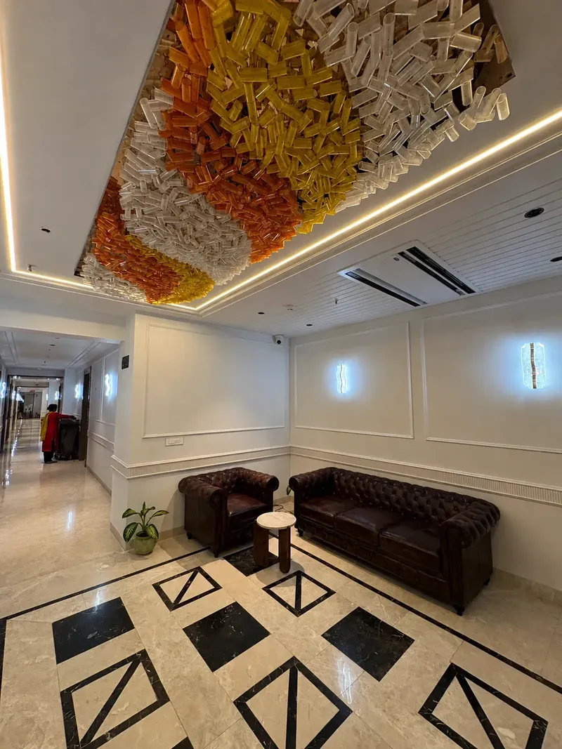Lobby — Ceiling Installation: a handcrafted glass installation anchors the lobby in amber and clear tones. Hotel Silk by Resham, Murthal, Haryana.