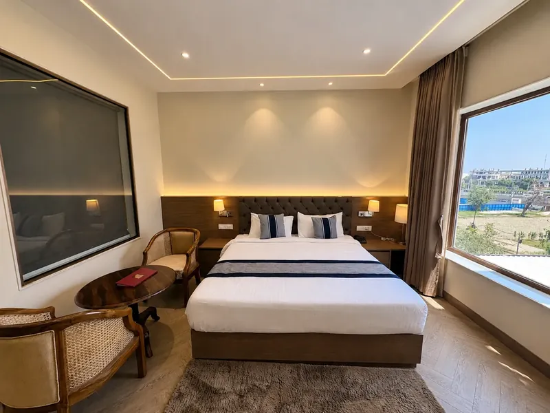 Suite Bedroom: a tufted headboard and cane seating warm a restrained palette. Hotel Silk by Resham, Murthal, Haryana.